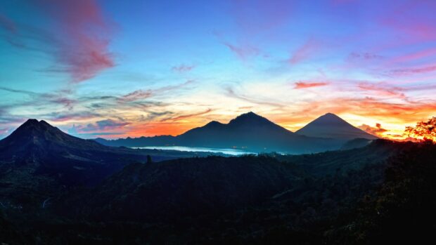 Stunning Bali sunrise over volcanic mountains and lush green hills