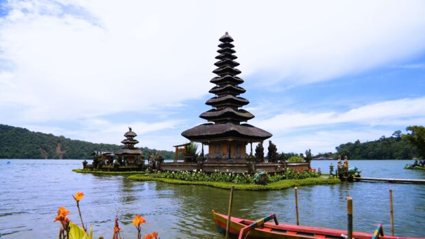 Traditional Balinese temple on a lake surrounded by lush greenery and flowers in Bali