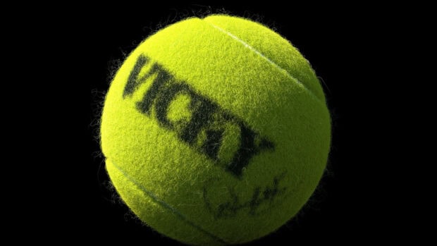 A close up of a bright green tennis ball showing its texture and brand name Wilson