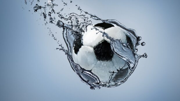 A soccer ball splashing through water captured in high detail with 4K quality