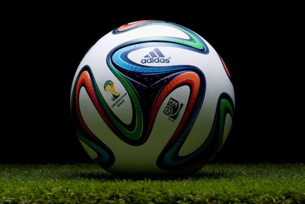 A soccer ball with colorful patterns on green grass field