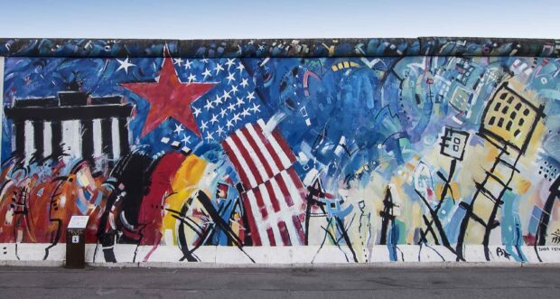 Artwork on the Berlin Wall includes stars and abstract shapes representing Berlin Wall