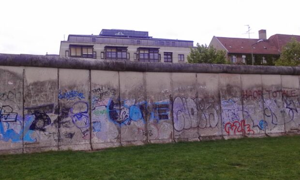 The Berlin Wall covered with colorful graffiti art in an urban setting
