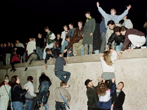 People climbing the Berlin Wall during the historic event of freedom in Berlin