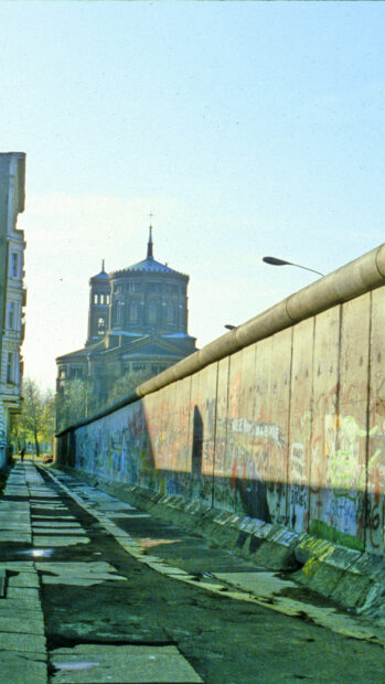 A historic view of Berlin Wall with surrounding architecture and street scene