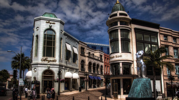 Historic Beverly Hills architecture with luxury shops and sculpture under cloudy sky