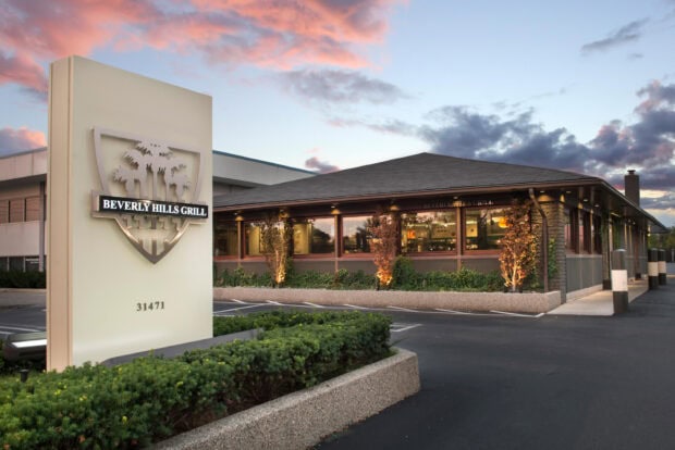 Beverly Hills Grill building exterior with sunset sky and palm trees decor