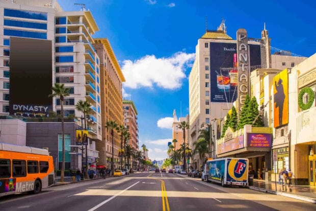 Downtown Beverly Hills street with palm trees and colorful buildings under clear blue sky