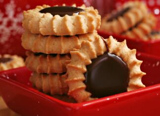 A close up of biscuit with chocolate center stacked in a red tray against a festive background
