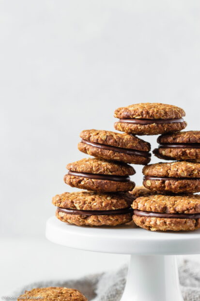 A stack of oat biscuit with chocolate filling displayed on a white cake stand