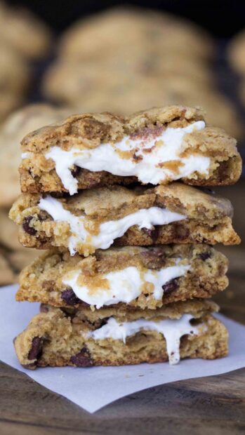 A stack of biscuit filled with melted marshmallow cream on parchment paper