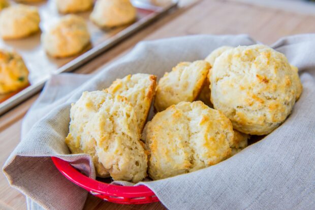 Fresh biscuit dough pieces in a red basket lined with cloth