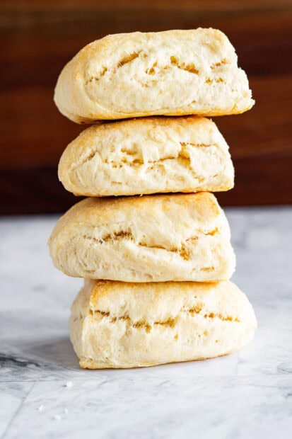 A stack of fresh soft biscuit pieces on a marble surface