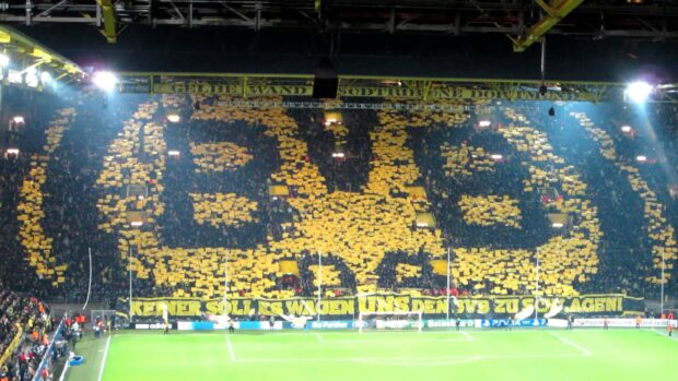 Borussia Dortmund fans creating a large yellow and black display in the stadium stands