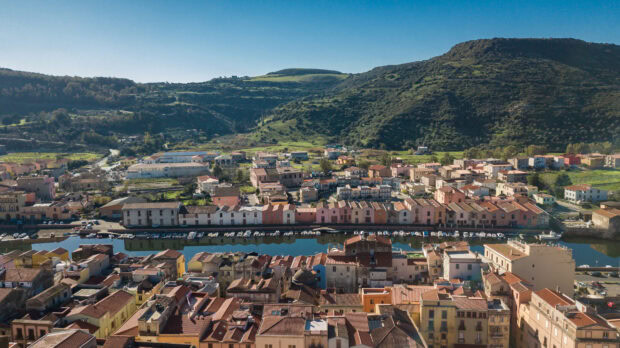 Aerial view of Bosa Italy town with hills and river featuring Bosa Italy architecture