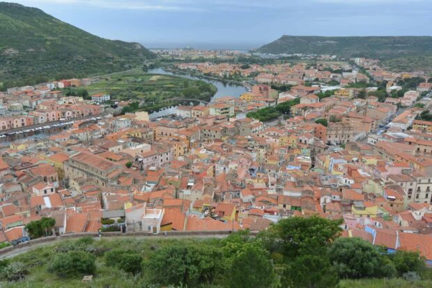 Aerial view of Bosa Italy town with colorful houses and river winding through the landscape