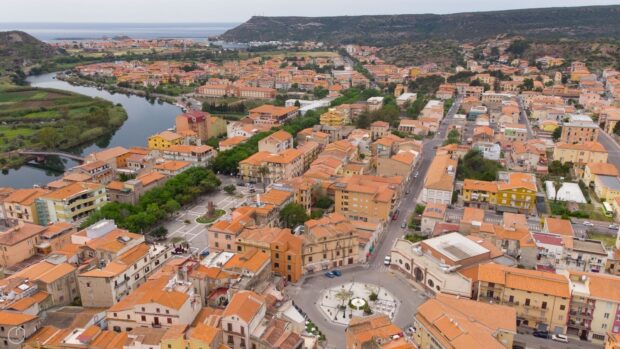 Aerial view of Bosa Italy town with river and colorful buildings in Italian countryside