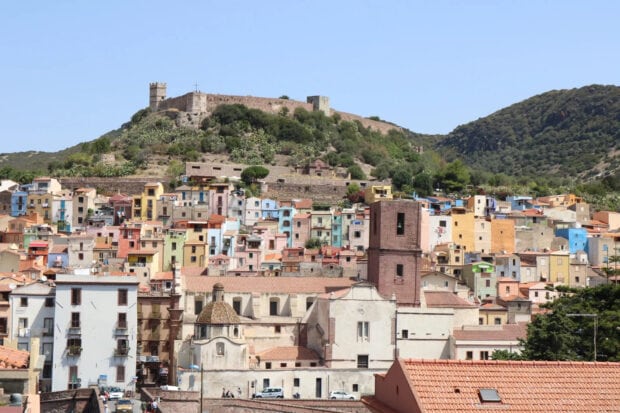 Colorful Bosa Italy town houses with mountains in the background
