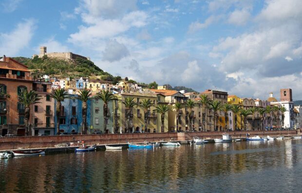 Colorful buildings in Bosa Italy with palm trees along the waterfront