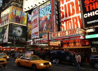 A busy Broadway street scene featuring iconic musical posters including West Side Story and Phantom