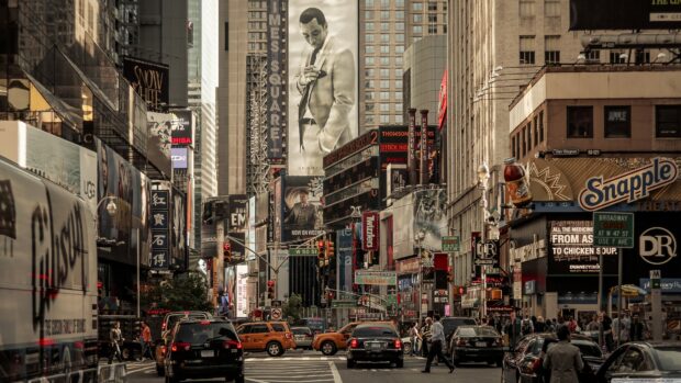 A busy street view of Broadway featuring tall buildings and billboards in New York City