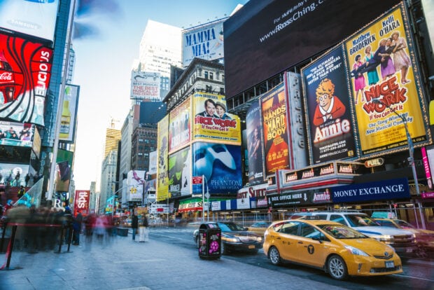 Busy Broadway street scene with colorful billboards and iconic taxis in New York City