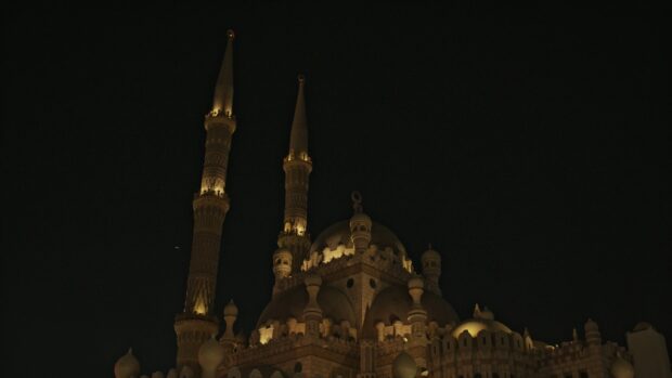 Illuminated mosque architecture in Cairo Egypt at night with detailed minarets and domes