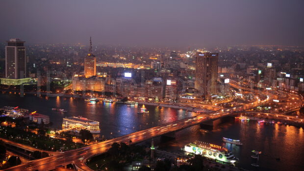 A stunning high quality view of Cairo Egypt cityscape at night with illuminated buildings and bridges over the Nile river
