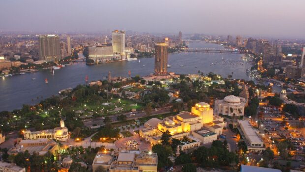 A panoramic view of Cairo Egypt cityscape featuring the Nile River and urban buildings at dusk