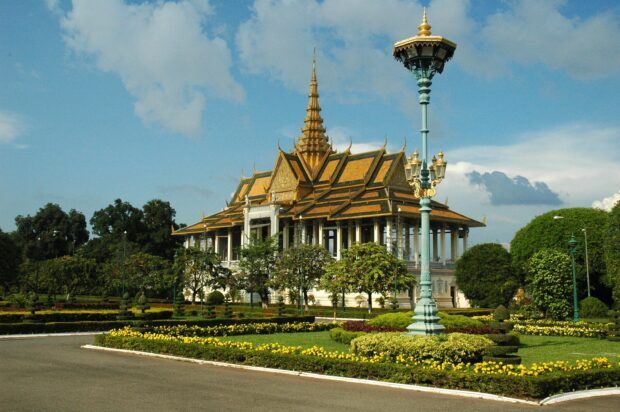 Ancient Cambodia architecture with golden temple roof and garden in daylight