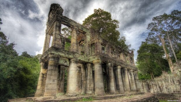 Ancient Cambodia temple ruins surrounded by green forest and cloudy sky