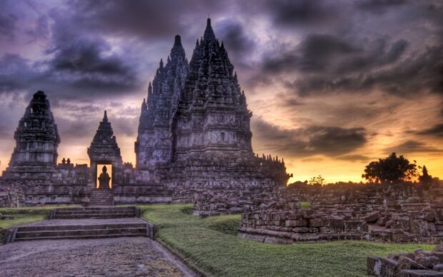 Ancient Cambodia temple ruins under a dramatic sunset sky in a peaceful landscape
