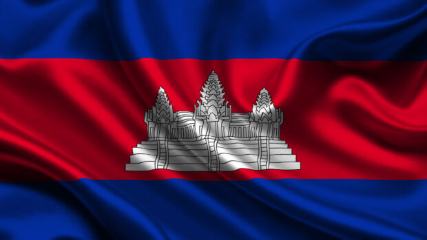 The Cambodian flag with Angkor Wat temple symbol on waving fabric background