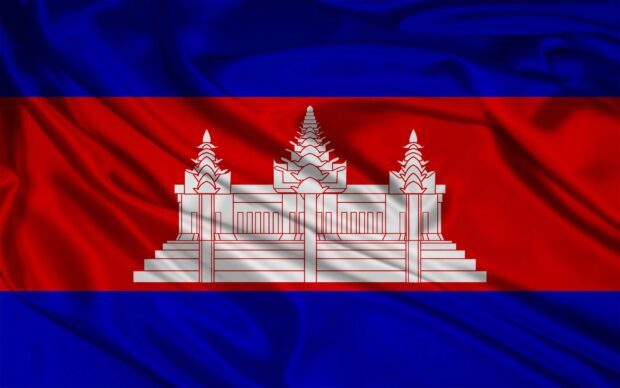 The flag of Cambodia with Angkor Wat temple in the center displayed on fabric texture