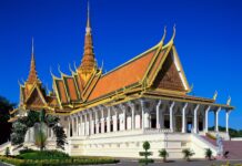 A traditional Cambodian building with ornate golden roof and clear blue sky in Cambodia