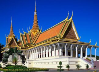 A traditional Cambodian building with ornate golden roof and clear blue sky in Cambodia