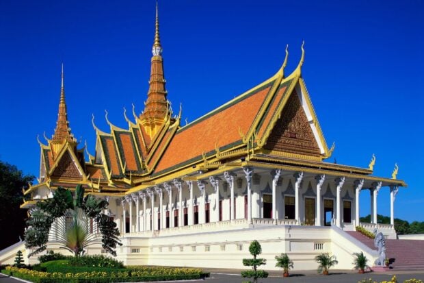 A traditional Cambodian building with ornate golden roof and clear blue sky in Cambodia