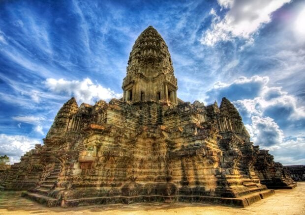 Ancient Cambodia temple under a bright sky with detailed stone carvings and architecture