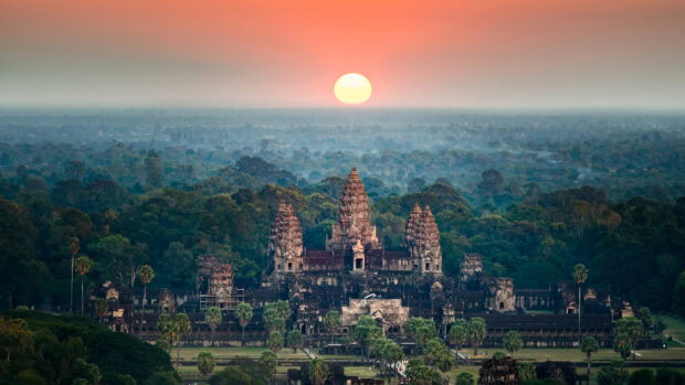 Ancient Cambodian temple surrounded by forest at sunrise in Cambodia