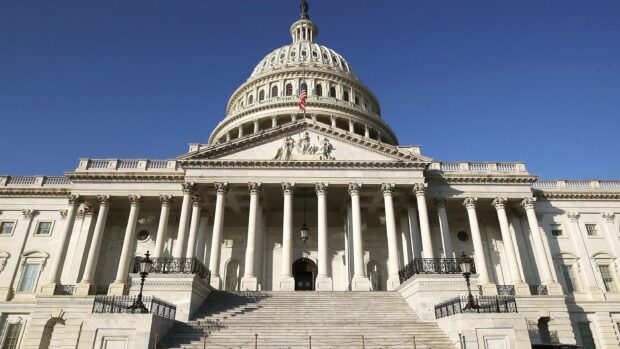 The Capitol Hill building with white columns and a clear blue sky