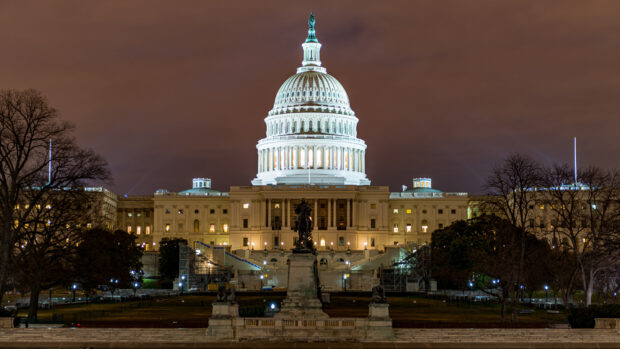 Capitol Hill lit up at night with detailed architecture and surrounding trees