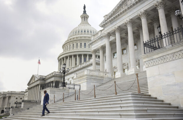 A man in a suit walking down the steps of Capitol Hill in Washington DC