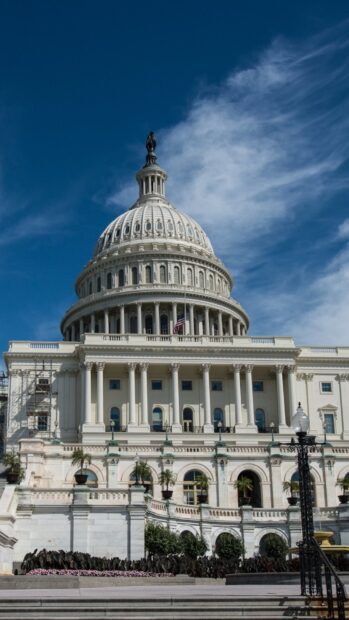 The iconic Capitol Hill dome stands tall against a vibrant blue sky with scattered clouds