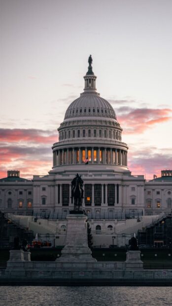 The Capitol Hill dome with statue in front at sunset with pink clouds in the sky