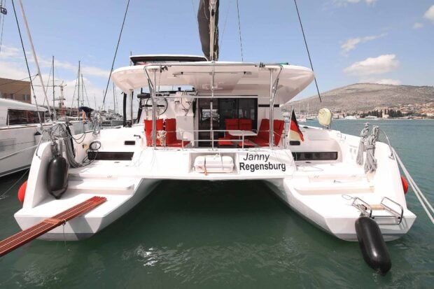 Modern catamaran docked at the harbor featuring spacious seating and clear blue skies