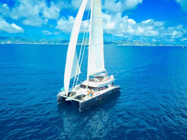 A catamaran sailing on the clear blue sea under a bright sky