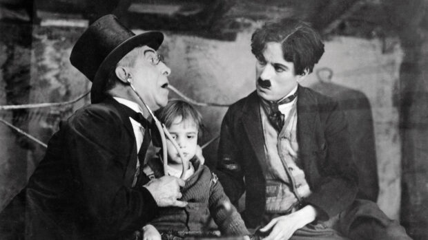 Charlie Chaplin in a vintage scene with a man and child showing classic silent film comedy style