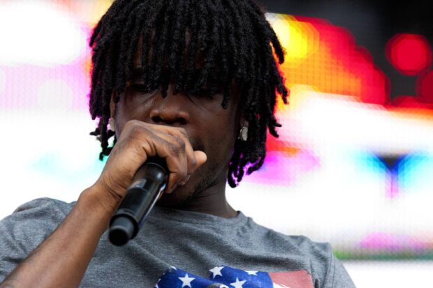 Chief Keef performing on stage with a microphone in hand