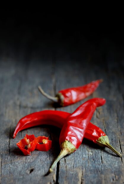 Red chili pepper with seeds on rustic wooden surface