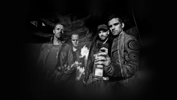 Coldplay band members standing in a dark moody setting with artistic shadows and reflections